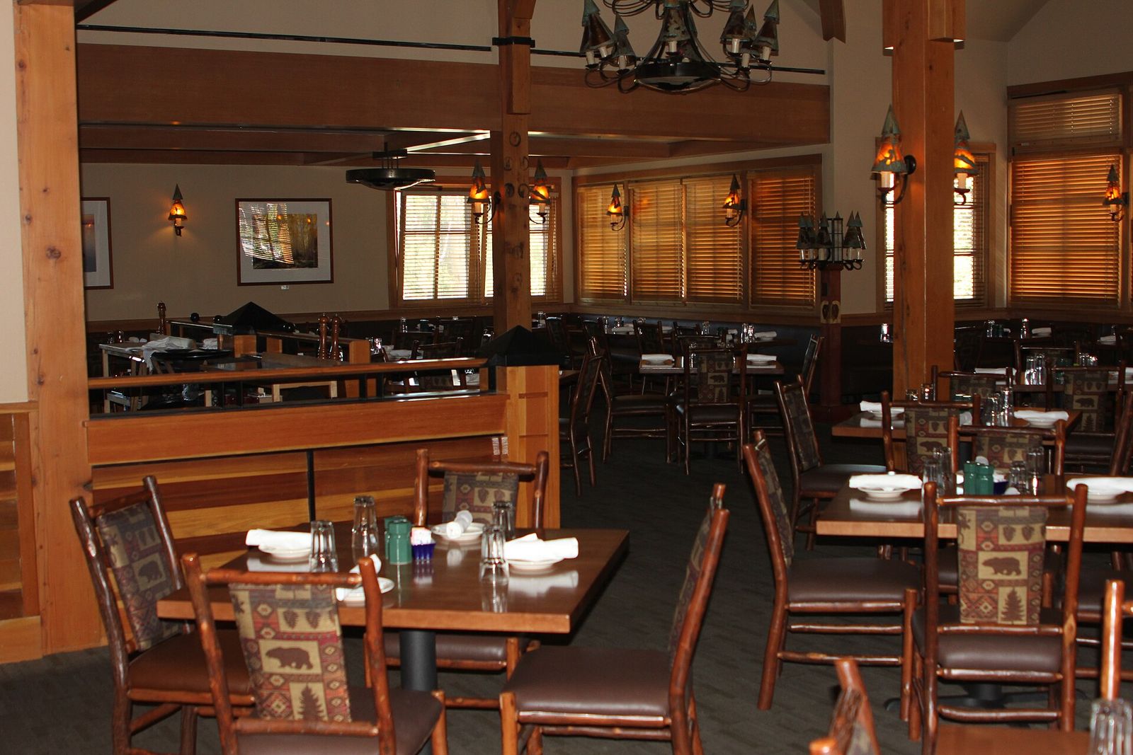 Timber-framed dining room with wooden tables and chairs laid for guests