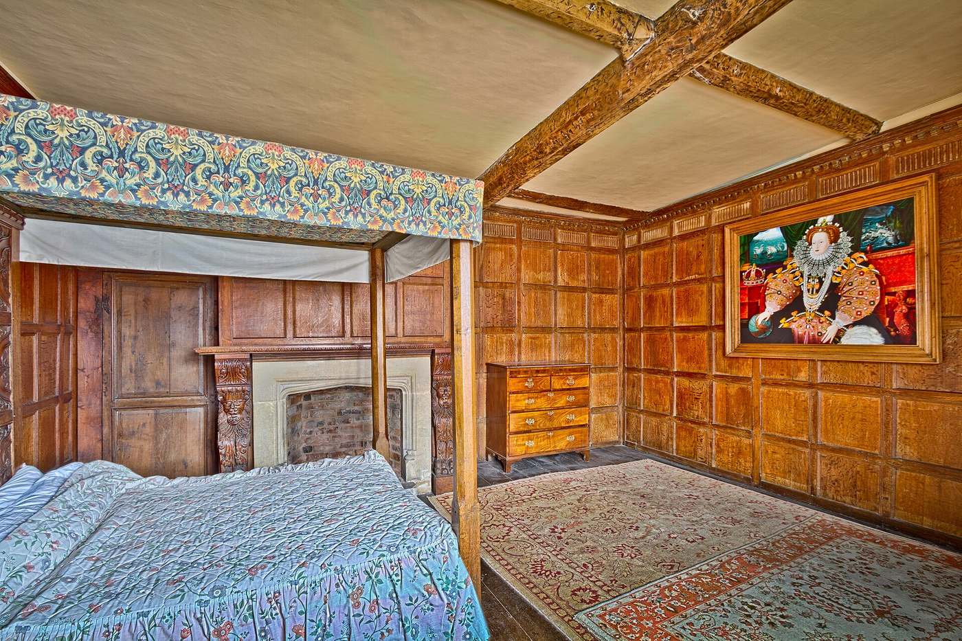 Room with a large bed and walls clad in warm timber