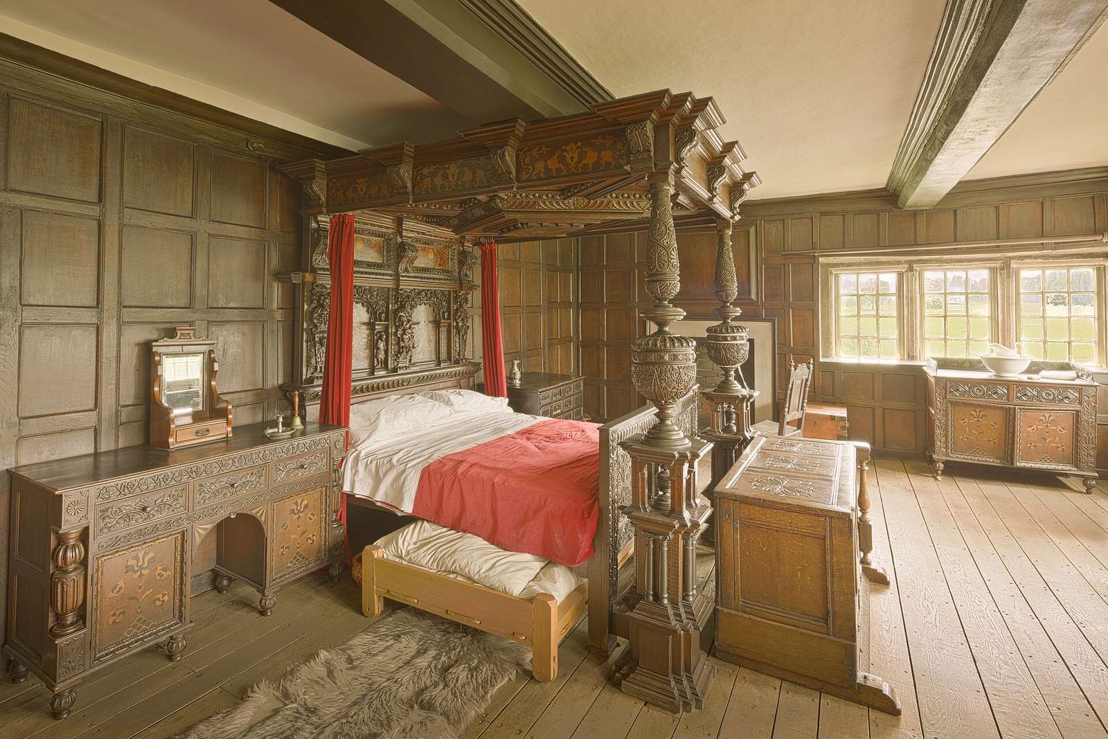 Spacious timber bedroom with a large bed, a chest of drawers and windows